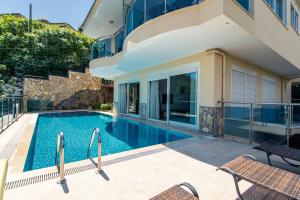 a swimming pool with chairs next to a building at Alanya Castle Apartment - Adult Only in Alanya