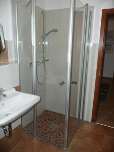a shower with a glass door next to a sink at Seesand in Wittdün