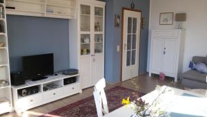 a living room with a tv and a couch and a table at Seesand in Wittdün