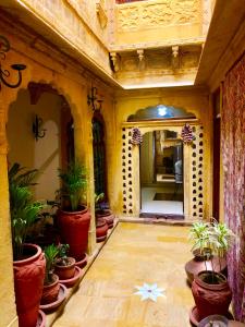 Habitación con macetas y espejo. en Hamari Haveli en Jaisalmer