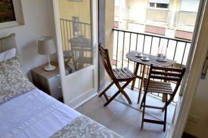 a bedroom with a bed and a table and a balcony at Modarno Exclusive Apartments in Florence
