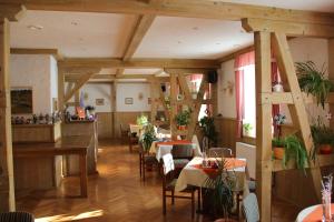 a restaurant with tables and chairs in a room at Landhaus Sonnentau in Johanngeorgenstadt