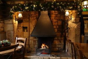 
a fireplace that has a fire place in it at Eight Bells Inn in Chipping Campden
