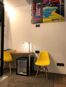 a table and two yellow chairs in a room at Airhostel Barcelona Airport 24h in El Prat de Llobregat