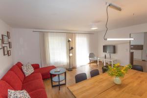 a living room with a red couch and a table at Haus Residence in Dreschvitz