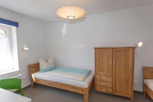 a bedroom with a bed and a wooden cabinet at Haus Residence in Dreschvitz