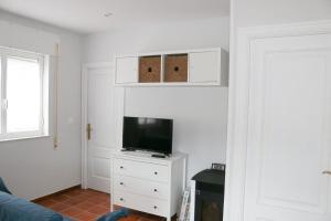 una sala de estar con TV en una cómoda blanca en Casa Viveiro, en Jove (Xove)