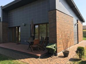 a house with a patio with a table and chairs at NK apartments in Druskininkai