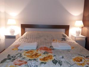 Apartments Mirković في ستنيي: سرير مع وسادتين ومصباحين في غرفة النوم