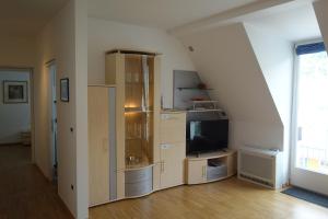 Hager Apartment 2 في ميرانو: غرفة معيشة مع تلفزيون ورف مع تلفزيون