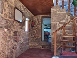 Habitación con pared de piedra y escalera. en Casa Padre Alexandre, en Covide