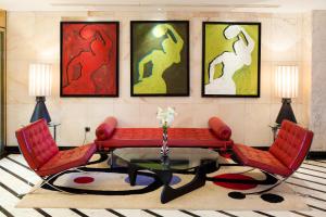 a living room with a red couch and two chairs at Seaside Palm Beach in Maspalomas