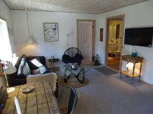 a living room with a couch and a table at Fin lejlighed med lukket have in Skagen