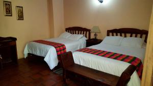 2 camas en una habitación de hotel con faldas en Posada Papa Chepe, en La Esperanza