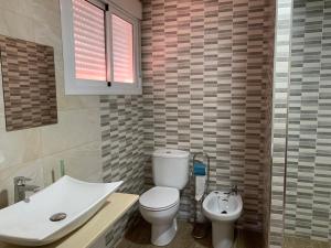 Un baño con un inodoro blanco y un lavabo. en Hostal Restaurante Rufino, en Berlanga