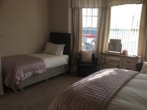 A bed or beds in a room at Glenora Guest House 