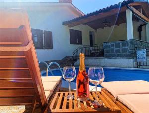 una botella de vino y dos copas de vino en una mesa en Holiday Home Deni, en Roč