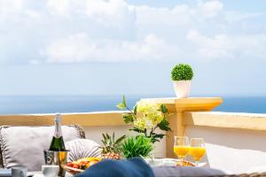 una mesa con copas de vino en un balcón con vistas al océano en Windsor Panoramic Las Americas, en Adeje