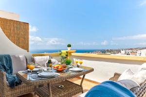 a table and chairs on a balcony with a view of the ocean at Windsor Panoramic Las Americas in Adeje