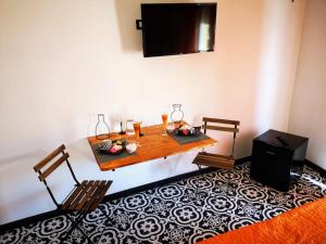 a dining room table with two chairs and a television at Trapani Destinations b&b in Trapani