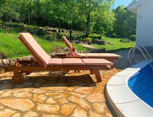 a bench and a table next to a swimming pool at Holiday Home Deni in Roč