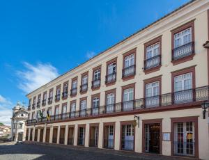um grande edifício com uma varanda numa rua em Hotel Solar do Rosário em Ouro Preto