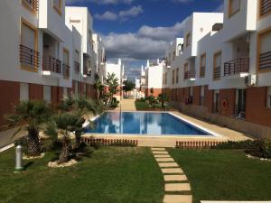 ein Pool in einem Hof neben einigen Apartmentgebäuden in der Unterkunft Gomeira Top Floor in Cabanas de Tavira