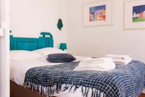 
a bedroom with a bed, desk, and painting on the wall at Like Home - Santos in Lisbon
