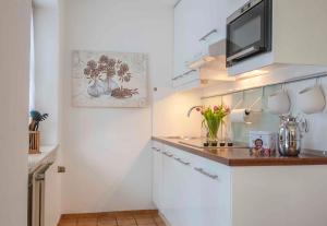 a small white kitchen with a counter and a microwave at Am Sonneneck - Wohnung 1 in Ruhpolding
