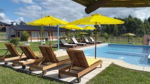 a group of chairs and umbrellas next to a pool at La Celmira in Concordia