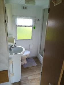 baño con lavabo y aseo y ventana en Domek holenderski, en Gawliki Wielkie