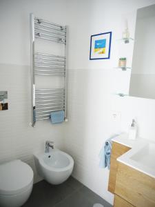 een witte badkamer met een toilet en een wastafel bij Vittoria home 44 in Terracina