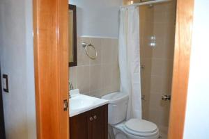 La salle de bains est pourvue de toilettes, d'un lavabo et d'une douche. dans l'établissement Hotel Kinich Ahau, à Valladolid