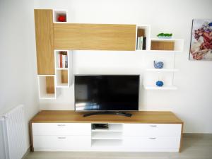 een woonkamer met een tv aan een witte muur bij Vittoria home 44 in Terracina
