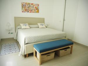 Cette petite chambre comprend un lit avec un banc bleu. dans l'établissement Vittoria home 44, à Terracine