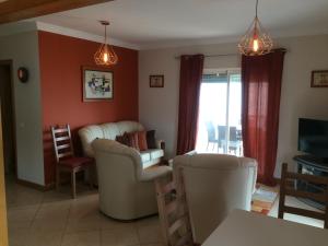 ein Wohnzimmer mit zwei Stühlen und einer Couch in der Unterkunft Gomeira Top Floor in Cabanas de Tavira
