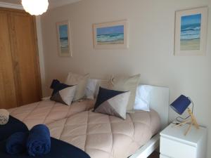 ein Schlafzimmer mit einem großen Bett mit Kissen darauf in der Unterkunft Gomeira Top Floor in Cabanas de Tavira + 58 Fotos