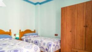 Un dormitorio con dos camas y un armario de madera. en Casa La Guitarra, en Nerja