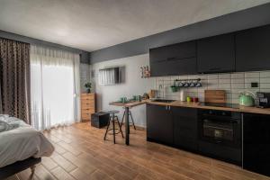 a kitchen with black cabinets and a bed in a room at LP Luxury Citycenter Studio in Xanthi