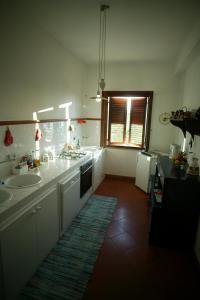 a white kitchen with two sinks and a window at Agriturismo Ridocco in Corleone