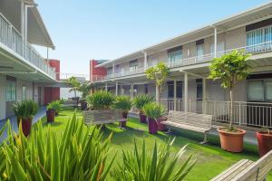 a courtyard of an apartment building with benches and plants at Awesome Downtown Location - park the car and walk to everything ! in Mount Maunganui
