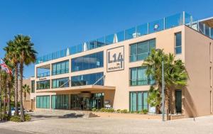 un grand bâtiment avec des palmiers devant lui dans l'établissement Salgados Beach Apartment 6A, à Albufeira