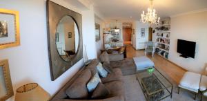 ein Wohnzimmer mit einem Sofa und einem Spiegel in der Unterkunft Inmejorables vistas a las islas Cies in Baiona