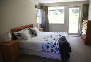a bedroom with a large bed and a window at waikawa house in Niagara