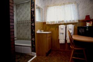 y baño con bañera, lavamanos y ducha. en Gateway Inn & Cabins en Ashford