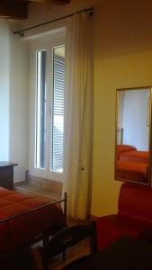 een kamer met een raam, een spiegel en een bed bij Antica Interamnia in Teramo