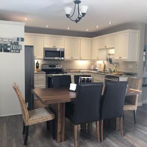 a kitchen with a wooden table and black chairs at The Whippoorwill Cottage - NBP-2022-201 in Lion's Head