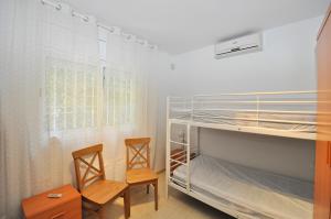 1 Schlafzimmer mit 2 Stühlen und 1 Etagenbett in der Unterkunft Villa Genova in Lloret de Mar + 34 Fotos