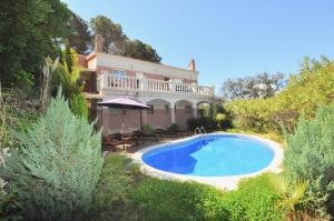 ein Haus mit einem Swimmingpool davor in der Unterkunft Villa Genova in Lloret de Mar