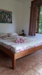- une chambre avec un lit orné de roses dans l'établissement Babilonia, à Cahuita
